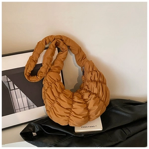 Detailaufnahme der braunen gesteppten Croissant-Tasche mit Falten und breitem Gurt