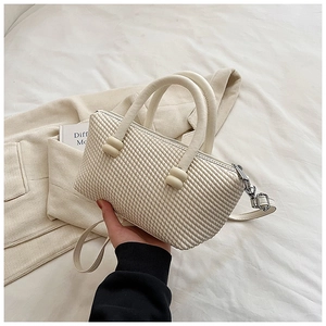 Détail du sac à main blanc crème avec texture gaufrée et doubles poignées cylindriques