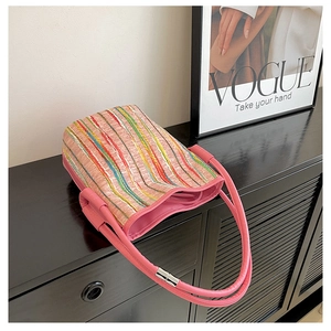 Détail d'un sac cabas tissé coloré avec bandoulière en cuir rose et boucle aimantée argent