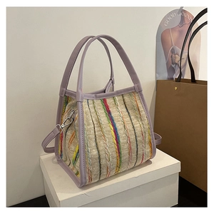 Detalle del bolso tote de tweed tejido colorido con correas de cuero lila y ganchos