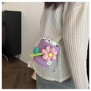 Close-up of a purple woven bucket bag with a pink flower and I'm stuck on you label