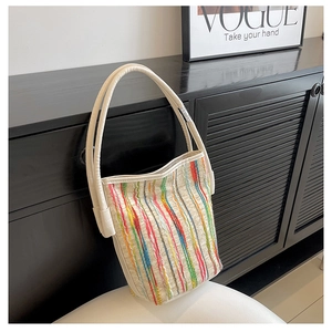 Gros plan détaillé des rayures tricotées colorées sur un sac fourre-tout beige