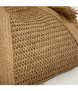 Detailed close-up of textured straw weaving and tassel on a khaki summer beach tote bag