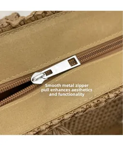 Detail of silver metal zipper closure and woven texture on summer straw tote bag