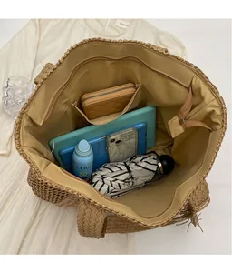 Detail view of khaki straw tote bag interior with zipper pocket and spacious capacity