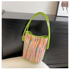 Détail d'un sac cabas tissé à rayures colorées avec anses vert néon et anneau en métal