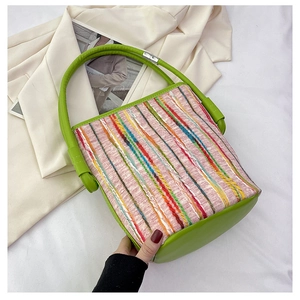 Détail d'un sac seau tissé coloré avec garniture et poignée en cuir vert pomme