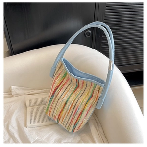 Détails du sac cabas tissé à rayures colorées avec des anses en cuir bleu clair élégant