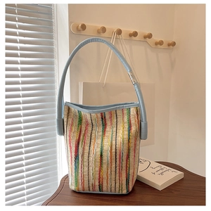 Détail du sac seau tissé à rayures colorées avec garniture en cuir bleu clair et ferrures