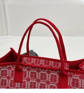 Detail of red woven bridal tote with sturdy rope handles and Chinese Xi character pattern