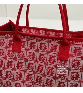 Detail of reinforced handles and stitching on a red Chinese wedding tote bag