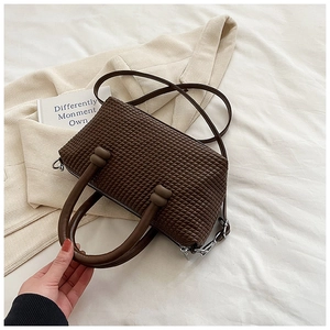 Détail du sac bandoulière marron café avec texture tissée et poignées à nœuds
