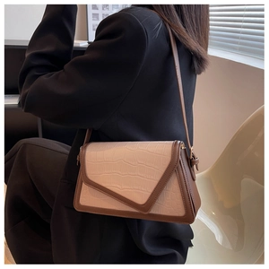 Detail of faux crocodile texture and bicolor design on a fashion shoulder bag