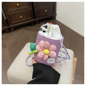 Close-up of purple woven bucket bag with 3D pink flower detail and drawstring inner