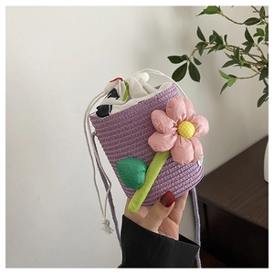 Macro shot of purple woven bucket bag with pink 3D flower detail and drawstring