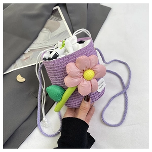 Detail of purple woven bucket bag featuring large pink floral decor and white drawstring inner