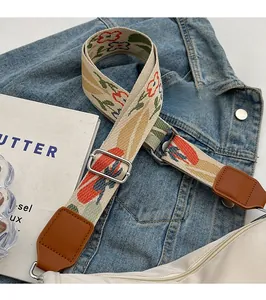 Detail of adjustable floral canvas strap with vintage embroidery and leather trim