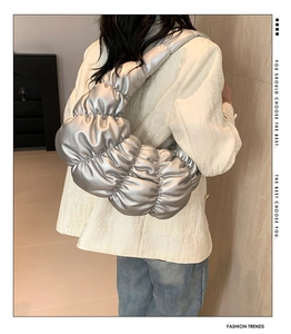 Detail of silver metallic pleated cloud bag with stylish ruched texture and wide strap