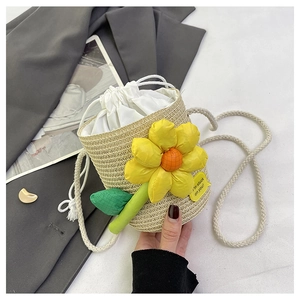 Detail of mini straw bucket bag with a large yellow sunflower and white drawstring liner