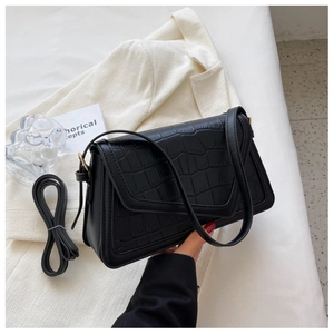 Close-up of black crocodile embossed PU leather shoulder bag with adjustable strap
