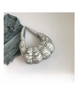Detail view of the silver pleated cloud bag showing metallic texture and soft sponge design