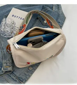 Detail view showing spacious interior of the cream crossbody bag with various essentials