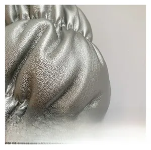 Macro detail of silver metallic cloud bag featuring ruched texture and pebbled finish