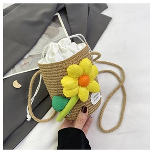 Detail of woven straw bucket bag with a yellow flower and white drawstring lining
