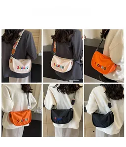 Nylon crescent crossbody bag with wide patterned strap and colorful embroidery