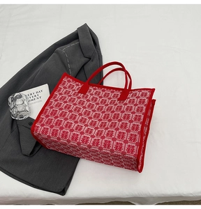 Close-up of red and white knitted tote bag with traditional Xi wedding patterns