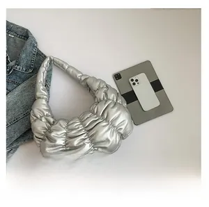 Detailed view of silver pleated hobo bag with a smartphone and tablet for size comparison