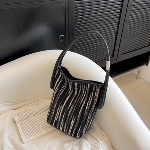 Sac fourre-tout tissé chic à rayures verticales noires et blanches sur un canapé