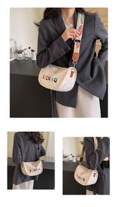 Detail of off-white canvas crossbody bag with colorful embroidery and wide jacquard strap