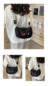 Detailed close-up of a crescent crossbody bag featuring wide ethnic print strap and embroidery