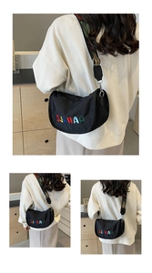Close-up of black crescent nylon bag with colorful embroidery and ethnic style wide strap