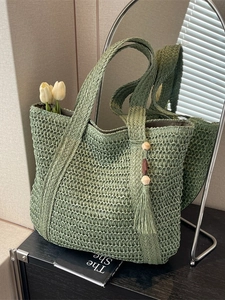 Summer woven straw tote bag in green with hollow mesh texture and long shoulder handles