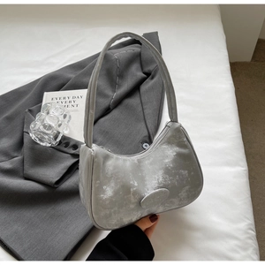 Dettaglio della borsa hobo argento con logo del marchio su un blazer grigio