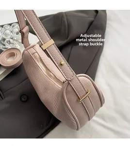 Detail of adjustable golden hardware buckle and lychee leather strap on pink bag