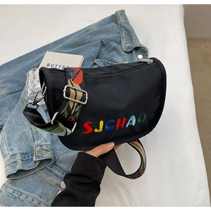 Detail of black crescent bag with SJCHAO embroidery and colorful jacquard wide strap