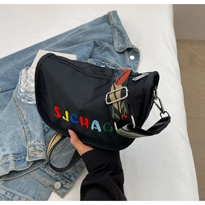 Detail of black canvas crossbody bag with SJCHAOL embroidery and colorful woven strap