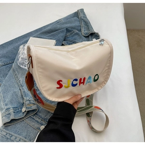 Close-up of cream crossbody bag with SJCHAO colorful embroidery and wide patterned strap