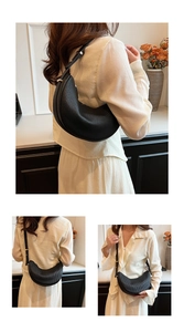 Detail of black crescent shoulder bag with vertical texture and gold hardware
