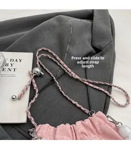 Detail of pink pleated handbag showing adjustable silver chain strap with sliding metal buckle