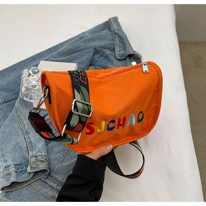 Detail of bright orange nylon saddle bag with SJCHAO embroidery and ethnic print strap