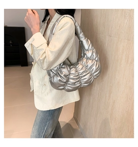 Detailed view of silver ruched cloud bag showing metallic synthetic leather texture