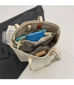 Interior view showing spacious multi-compartment storage of the woven tote bag