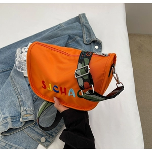 Detail of orange nylon crossbody bag with SJCHAC embroidery and wide woven strap
