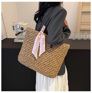 Detail of a large straw tote bag with a pink heart pattern silk scarf for summer beach