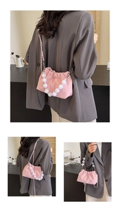 Detail of pink pleated cloud bag featuring houndstooth texture and white pearl bead handle