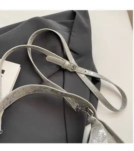 Detail of adjustable silver cracked texture shoulder strap with metallic buckle